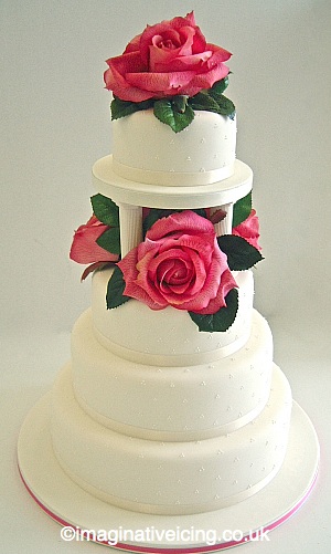 Ivory Wedding Cake Stacked with Pillars and large Roses
